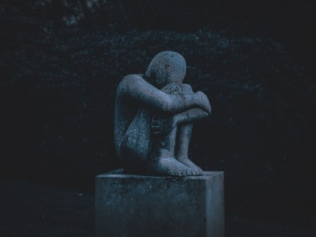 statue-of-a-boy-sitting-depressed-holding-head